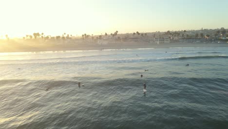 Toma-Aérea-Del-Amanecer-Rodeando-A-Los-Surfistas-En-Ocean-Beach-San-Diego-California
