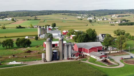 Farm-buildings,-grain-storage-silos,-rural-American-farmland-and-agriculture-theme,-aerial-in-Narvon-Lancaster-County-Pennsylvania-USA