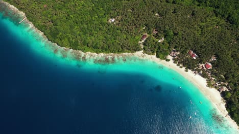 Drone-flying-over-blue-water,-beach-and-palm-trees-on-island-in-Sumatra,-Indonesia