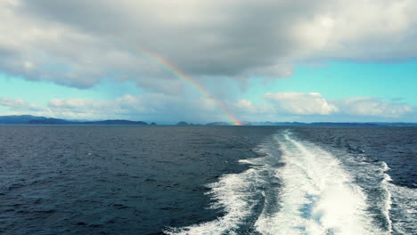 Traveling-Through-Blue-Ocean-In-Bay-Of-Islands-At-New-Zealand-With-Distant-View-Of-Rainbow-In-Background