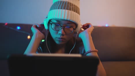 Junge-Asiatische-Frau,-Die-Musik-über-Kopfhörer-Und-Laptop-Hört
