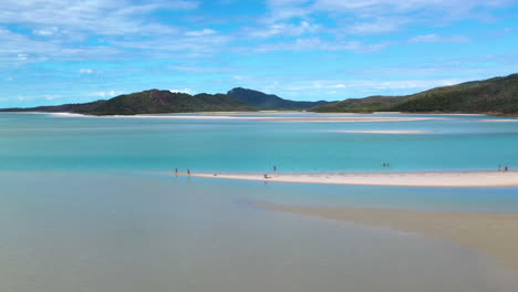 Tracking-drone-shot-of-people-on-beautiful-sandy-beach-at-Whitehaven-Beach-Whitsunday-Island-Australia