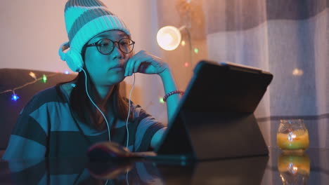 Chica-Asiática-Escuchando-Y-Sintiendo-La-Música-Con-Auriculares-Y-Una-Computadora