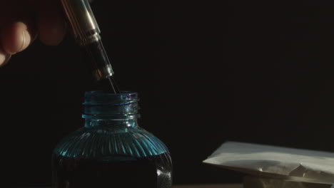 Fountain-pen-on-ink-bottle-with-letters-on-table-as-dust-floats,-pan