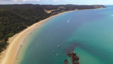 Tangalooma-shipwrecks-off-Moreton-Island-coast,-Australia,-high-aerial-reveal