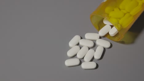 Opioid-weiße-Pillen,-Die-Auf-Dem-Tisch-Für-Gesundheitssucht,-Schmerzmedizin,-Grauer-Tischhintergrund-Verschüttet-Wurden