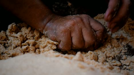 close-up-of-hand-kneading-tight-dough-in-a-wooden-plate