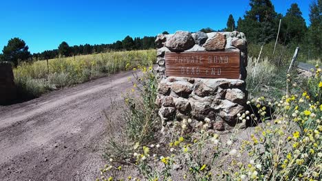 A-private-country-road-is-marked-with-a-stone-pillar-and-wooden-sign,-Flagstaff,-Arizona