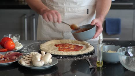 Ein-Koch,-Der-Pizzateig-Tomatensauce-Hinzufügt,-Während-Er-Einen-Traditionellen-Pizzakuchen-Zubereitet