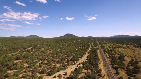 Aerial,-pan-across-the-landscape-and-railroad-tracks-north-of-Williams,-Arizona