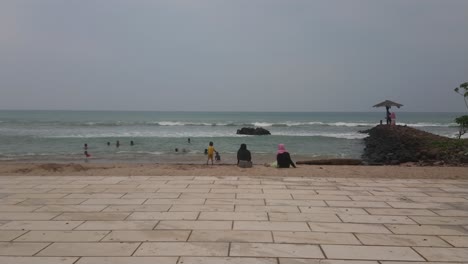 Strandatmosphäre-Im-Urlaub,-Viele-Leute-Am-Strand,-Morgens-Im-Meer-Schwimmen