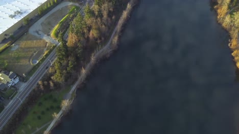 Luftdrohnenaufnahme-Des-Wapato-Sees-Mit-Reflexionen-Des-Blauen-Himmels-Und-Flauschiger-Wolken-Im-Wasser-Und-Der-Belebten-Autobahn-I-5-In-Tacoma,-Washington-An-Einem-Hellen-Nachmittag