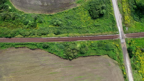 Chase-railroad-track-enclosing-wood's-panning-left-to-right-aerial-drone-shot