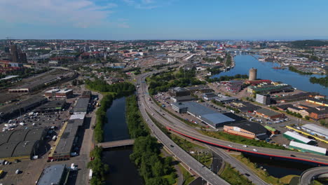 Aerial-View-Of-Modern-Freeway-In-Gothenburg,-Sweden-With-Small-Bridge-Over-Gota-River-On-A-Sunny-Day---drone-shot
