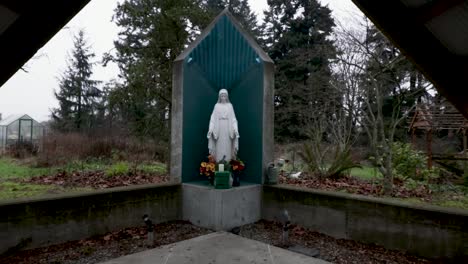 Zoom-in-Aufnahme-Einer-Statue-Der-Jungfrau-Maria-In-Einem-Außenaltar-Im-Park-An-Einem-Bewölkten-Tag