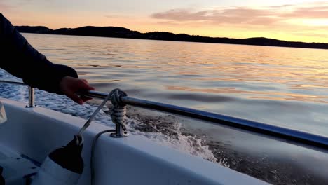 Driving-with-a-small-boat-on-a-fjord-in-norway-at-sunset