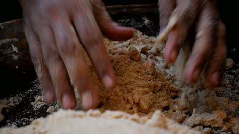 close-up-of-hand-kneading-dough-mixing-flour