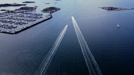Boats-speeding-over-the-waters-of-Långedrag,-Gothenburg,-Sweden---aerial