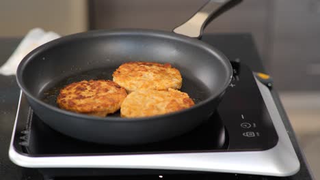 Close-up-of-frying-chicken-burger-patties-on-a-hotplate