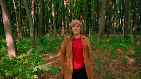 Caucasian-women-with-an-overcoat-and-hat-walking-in-the-forest-trail