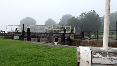 Industrial-British-canal-lock-gates-towpath-on-English-misty-morning-parallax-right