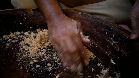 close-up-of-man-kneading-flour-dough-in-a-wooden-tray