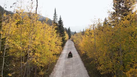 An-ATV-Off-roading-On-The-Mountain-Trail-Through-Beautiful-Trees-In-Wasatch-Mountain-Range,-Utah-During-Autumn---high-angle-shot,-slow-motion