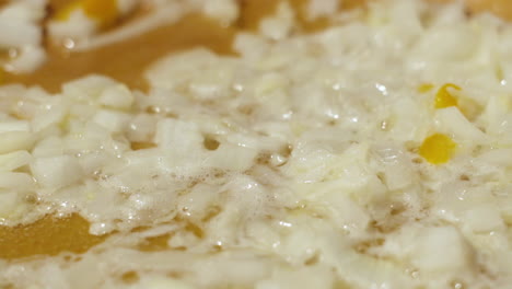 Close-up-diced-onions-sizzling-in-pan-in-slow-motion
