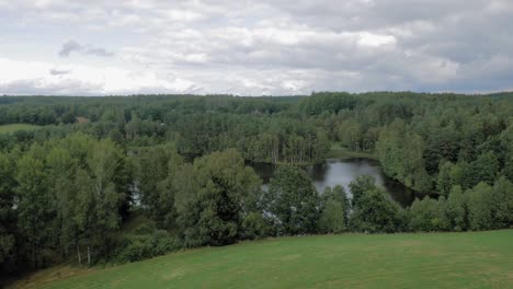 Üppig-Grüne-Bäume-Rund-Um-Den-Ruhigen-See-In-Der-Nähe-Des-Dorfes-Piaszno,-Gesehen-Von-Den-Berghügeln-An-Einem-Hellen-Tag-In-Der-Woiwodschaft-Pommern,-Nordpolen