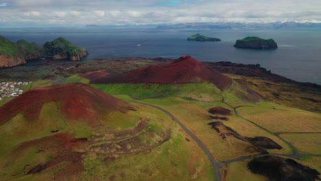 Drone-Descendiendo-Sobre-Cráteres-Volcánicos-En-Las-Islas-Westman,-Islandia---Ferry-En-El-Fondo---Sur-De-Islandia---Toma-Aérea