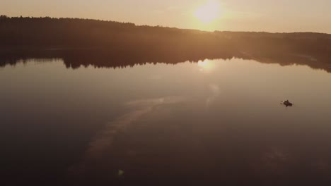Person,-Die-Ein-Schlauchboot-Auf-Einem-Ruhigen-Und-Ruhigen-Wasser-Des-Sees-Bei-Einem-Goldenen-Sonnenuntergang-In-Der-Nähe-Des-Dorfes-Rogowko,-Polen,-Paddelt