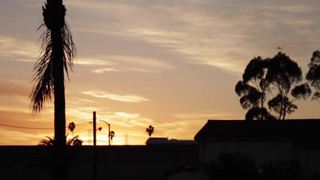 Plane-Flies-Away,-Above-and-Over-Freeway-and-Palm-Trees-into-Golden-Sunset,-Slow-Motion