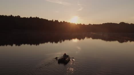 Person-In-Einem-Schlauchboot-Am-See-Mit-Reflexion-Eines-Lebendigen-Sonnenuntergangs-In-Rogowko,-Polen