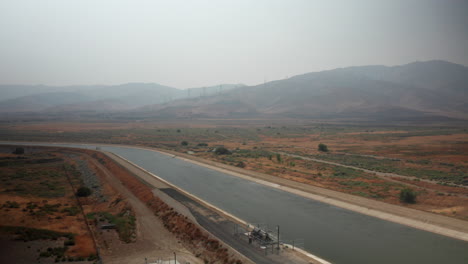 Aerial-view-of-the-California-aqueduct-and-trail-near-Palmdale-on-a-day-with-smoky-haze-from-wildfires