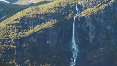 Schöne-Aufnahme-Eines-Langen-Wasserfalls,-Der-Große-Berge-Herunterfällt,-Sonniger-Tag-Und-Kamera-Leicht-Lastwagen