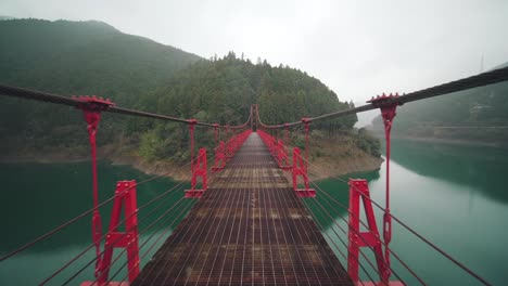 Point-Of-View-Of-A-Person-Crossing-Zaobashi-Suspension-Bridge-Over-Arita-River-On-A-Foggy-Day-In-Wakayama-Prefecture,-Japan