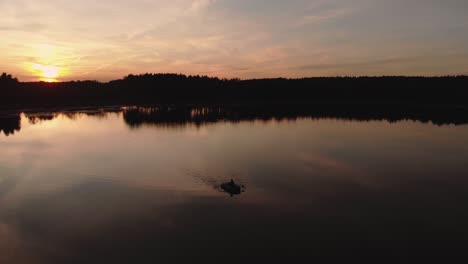 Beautiful-Sunset-And-Calmness-Of-A-Lake-With-Person-Paddling-A-Rubber-Boat-During-Summer-Evening-In-Rogowko,-Poland