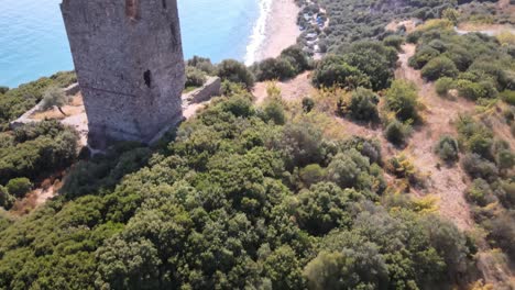 Aerial-drone-clip-overhead-an-ancient-ruined-tower-and-a-beach-in-Kavala,-Macedonia,-Greece