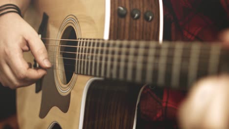 Close-up-of-a-western-acoustic-guitars-neck-and-strings-while-guitar-chords-are-being-played-on-it-by-a-professional-musician