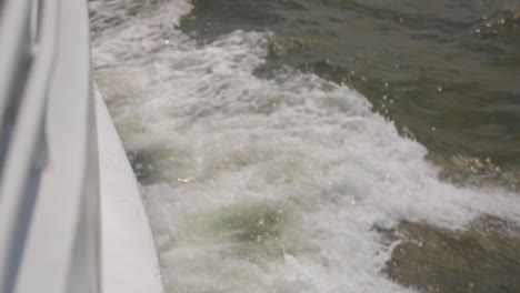 Waves-Splash-Alongside-Wake-of-Boat,-Slow-Motion-Depth-of-Focus