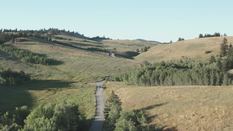 Luftaufnahme-Der-Straße-Durch-Grasbewachsene-Hügel-In-Der-Malerischen-Kanadischen-Landschaft