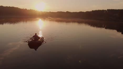 Kerl,-Der-Ein-Schlauchboot-Auf-Einem-Ruhigen-See-Während-Eines-Schönen-Sommersonnenuntergangs-In-Rogowko,-Polen-Paddelt