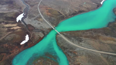 Car-Crossing-Bridge-Over-The-Beautiful-Flowing-Emerald-Glacier-River-Hvita-In-Highlands,-Iceland---Aerial-Drone-Shot