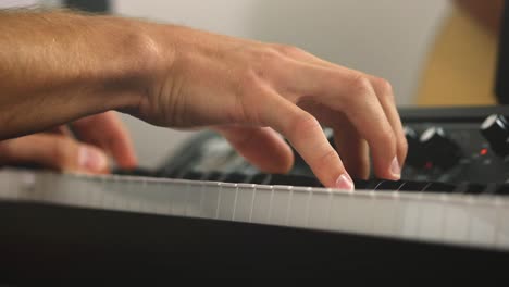 Close-up-sliding-shot-of-a-professional-piano-players-and-stage-pianos-keys-while-playing-chords-during-a-recording-session-with-a-bright-background