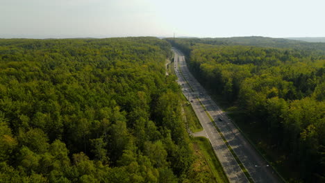 Aerial-panoramic-view-of-a-highway-in-the-middle-of-a-big-forest-in-Poland