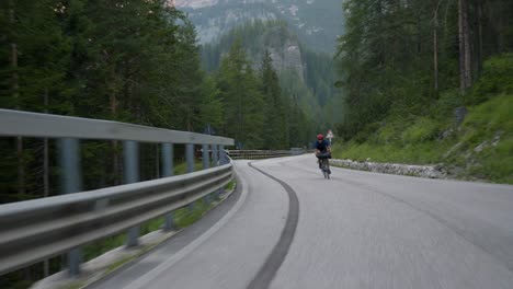 Cyclist-racing-on-the-roads-through-the-mountains-in-the-Dolomites-in-Italy-Europe