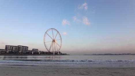 Time-Lapse-big-wheel-in-Dubai-Marina,-sunrise,-wide-angle,-static-shot