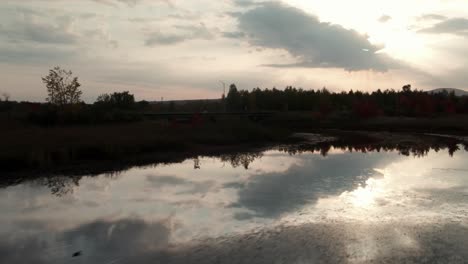 Fliegen-über-Die-Ruhigen-Wasser-Des-Flusses-Mit-Reflexionen-Des-Himmels-Während-Des-Sonnenuntergangs-In-Magog,-Quebec,-Kanada