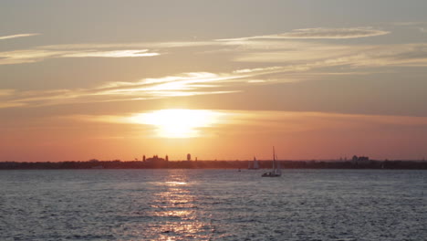 Sailboats-Move-Across-Ocean-Water-During-a-Golden-Sunset