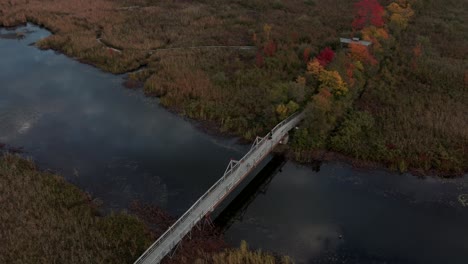 The-Wooden-Bridge-Over-The-Cours-D'eau-Shonyo-To-Lake-Memphremagog-At-Eastern-Townships-In-Quebec,-Canada-During-Fall-Season